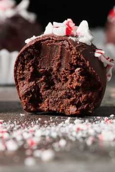 a chocolate cupcake with candy canes and white frosting on it's side