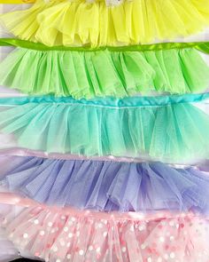 several different colored tulle skirts are lined up