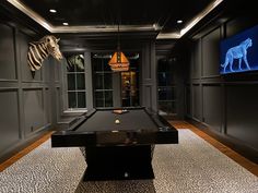 a room with a pool table and zebra on the wall