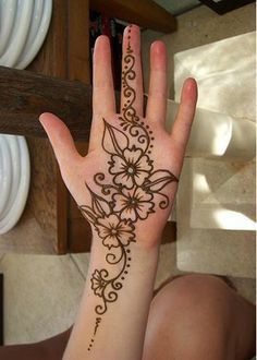 a woman's hand with a henna tattoo on it