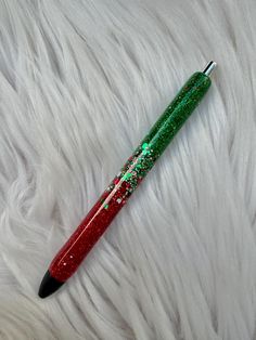 a red and green pen sitting on top of a white fur covered floor with lots of glitter