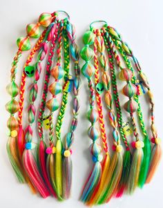 One pair of Braids Green/Yellow/Watermelon/Light Blue 7 braids each + hair wrap 22" long * Great for parties, birthdays, festivals, concerts, etc * Handmade tie in braid extensions * Reusable - wear again & again * Super easy to attach to your own hair                     🧡  💛  💚  💙  💜   This set of braids include  bubble braids, rope braids,  3 strand braids, infinity braids  and topsy-tail braids.  Made from a lightweight custom blend of synthetic hair in green, yellow, light blue and watermelon colors.  Adorned with hair charms and Pom-poms.                       🧡  💛  💚  💙  💜 CARE INSTRUCTIONS: * Avoid Heat. Synthetic braids cannot withstand heat styling so avoid using hot styling tools to prevent melting or damage. * Storing. When not wearing, it's best to either hang them u Braids Green, Infinity Braids, Rave Braids, Yellow Watermelon, Hair Braid Beads, Topsy Tail, Braid Extensions, Synthetic Braids, Rope Braids