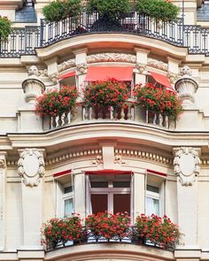 an apartment building with flower boxes on the balcony and balconies in the windows