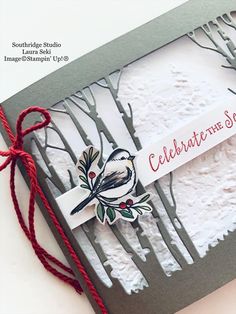 a close up of a card with a bird on it and some red string around the edge