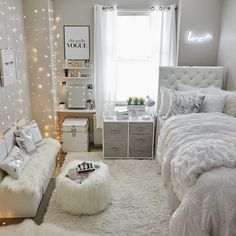 a bedroom decorated in white and silver with lights on the walls, bedding, rugs and pillows