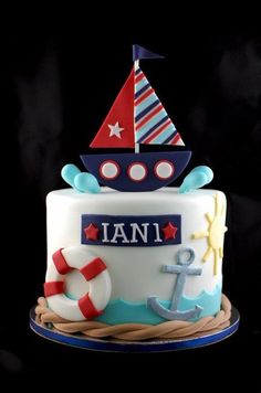 a cake decorated with an anchor, boat and life preserver is shown on a black background