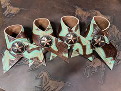 four brown and turquoise leather cowboy boots with star decorations on the sides, sitting on a table