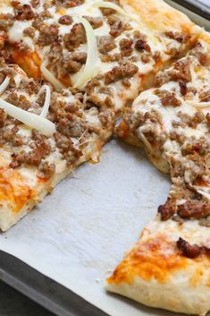 a pizza sitting on top of a pan covered in cheese and meat toppings with one slice missing