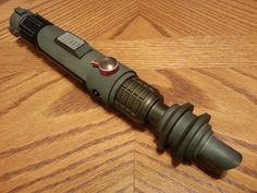 a green flashlight sitting on top of a wooden table