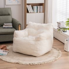 a white bean bag chair sitting on top of a wooden floor next to a window