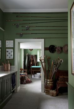 a hallway with green walls and lots of items on the wall, including fishing rods