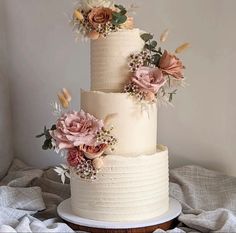 there is a three layer cake with flowers on it