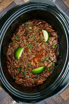 a crock pot filled with shredded meat and apples