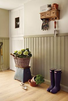 a basket filled with flowers sitting on top of a wooden floor next to gardening utensils