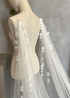 a mannequin wearing a white veil with flowers on it