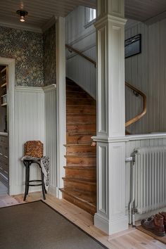 a chair sitting on top of a hard wood floor next to a wooden stair case