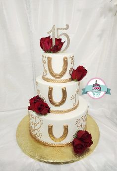 a white and gold wedding cake with red roses