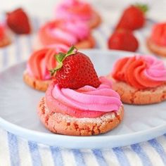 strawberry shortcakes with pink frosting on a plate