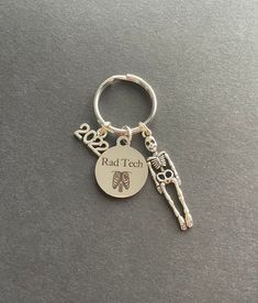 a metal keychain with a skeleton on it and the words dead tech printed on it