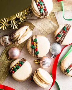 Gingerbread macarons wilth Christmas sprinkles on top and surrounded by Christmas ornaments and ribbons. Gingerbread Macarons, Gingerbread Buttercream, Macarons Easy, Festive Cookie Recipes, Christmas Macarons, Macaron Flavors, Holiday Desserts Table, White Chocolate Cookies, Christmas Sprinkles