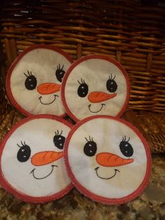 four snowman plates sitting on top of a counter next to a wicker basket