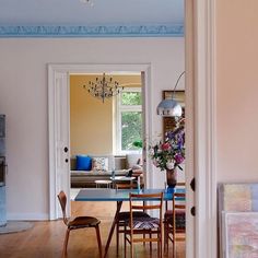 a dining room table and chairs in front of an open door to a living room