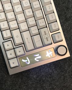 a close up of a computer keyboard on a table with numbers and symbols painted on the keys