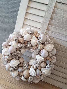 a wreath made out of seashells and burlocks on the front door