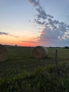 hay bales in a field at sunset