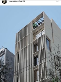 a tall building with lots of windows next to trees