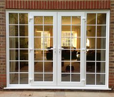 a white double door with glass panes and brick wall in front of a living room