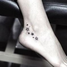 a woman's foot with stars tattoo on it