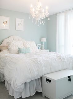 a white bed sitting in a bedroom next to a window