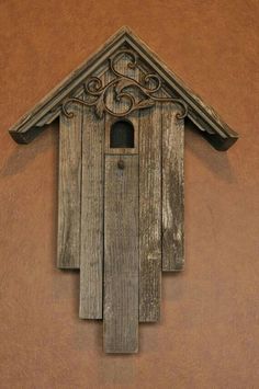 a birdhouse made out of wood with a roof and window on the outside wall