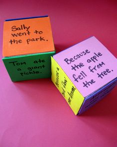 two boxes with words written on them sitting next to each other in front of a pink background