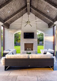 an outdoor living area with couches and a fireplace