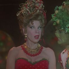 there are two women dressed in costumes and one is wearing a tiara with holly wreaths on her head