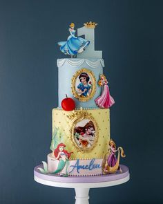 a three tiered cake with disney characters on it