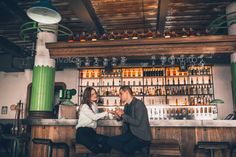 a man and woman sitting at a bar