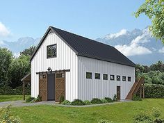 a large white barn with a black roof and two doors on the side of it