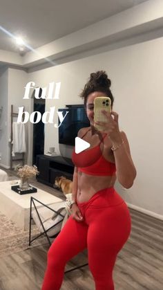 a woman taking a selfie in her red sports bra and matching leggings