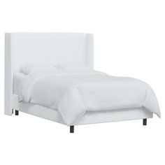 a bed with white sheets and pillows on it