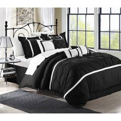 a black and white bed with zebra print on the comforter, pillows and rugs