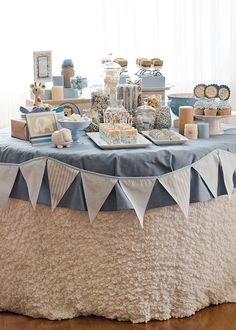 the table is set up with desserts and decorations for a baby's first birthday