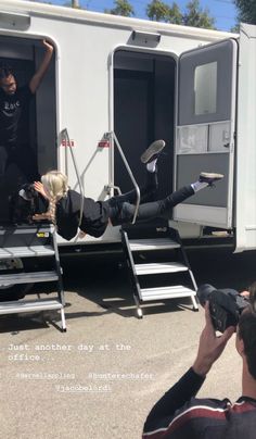 a man is falling off the side of a bus while another person photographs him from behind