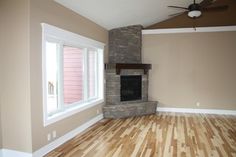 an empty living room with wood floors and a fireplace