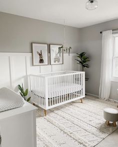 a baby's room with a white crib and pictures on the wall