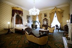 an ornate bedroom with fancy furniture and chandelier