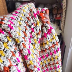 a woman is wrapped in a crocheted blanket