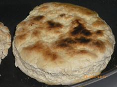 two uncooked pizzas sitting on top of a pan